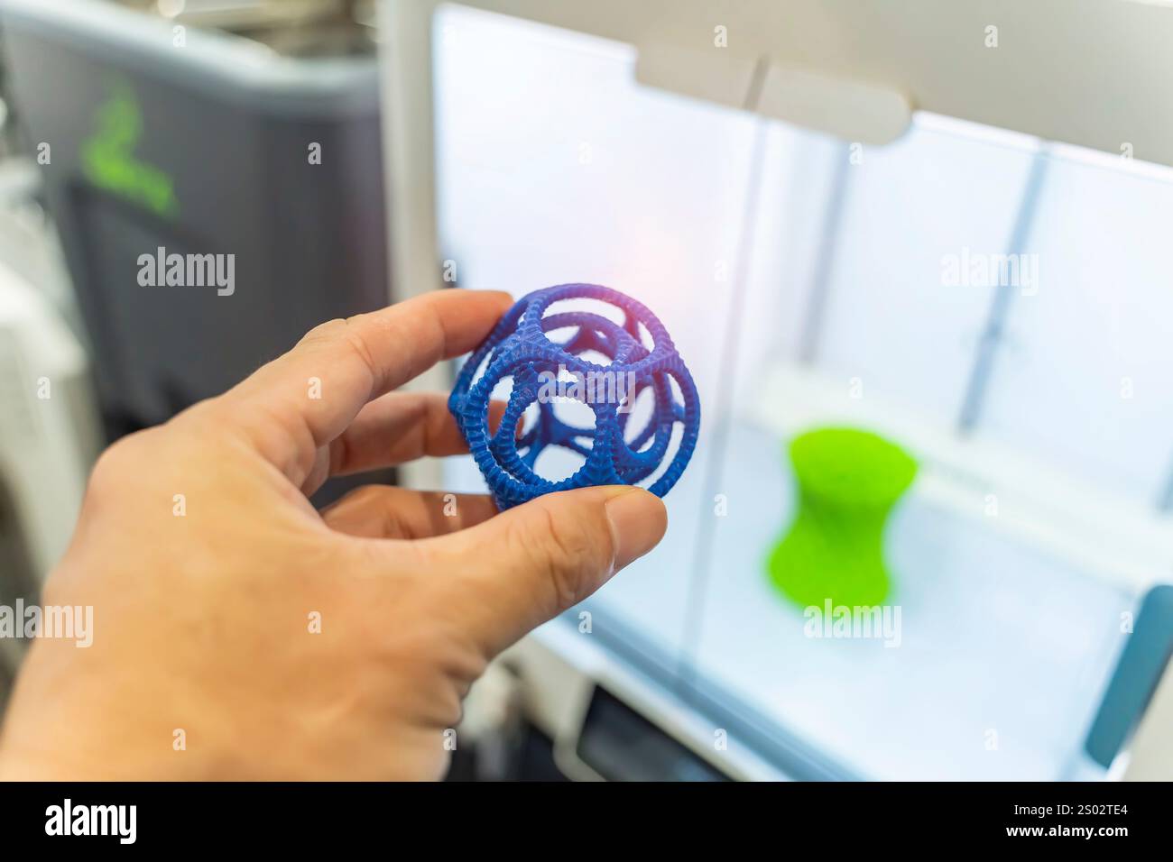 hand with hollow sphere object printed on 3d printer close-up Stock Photo