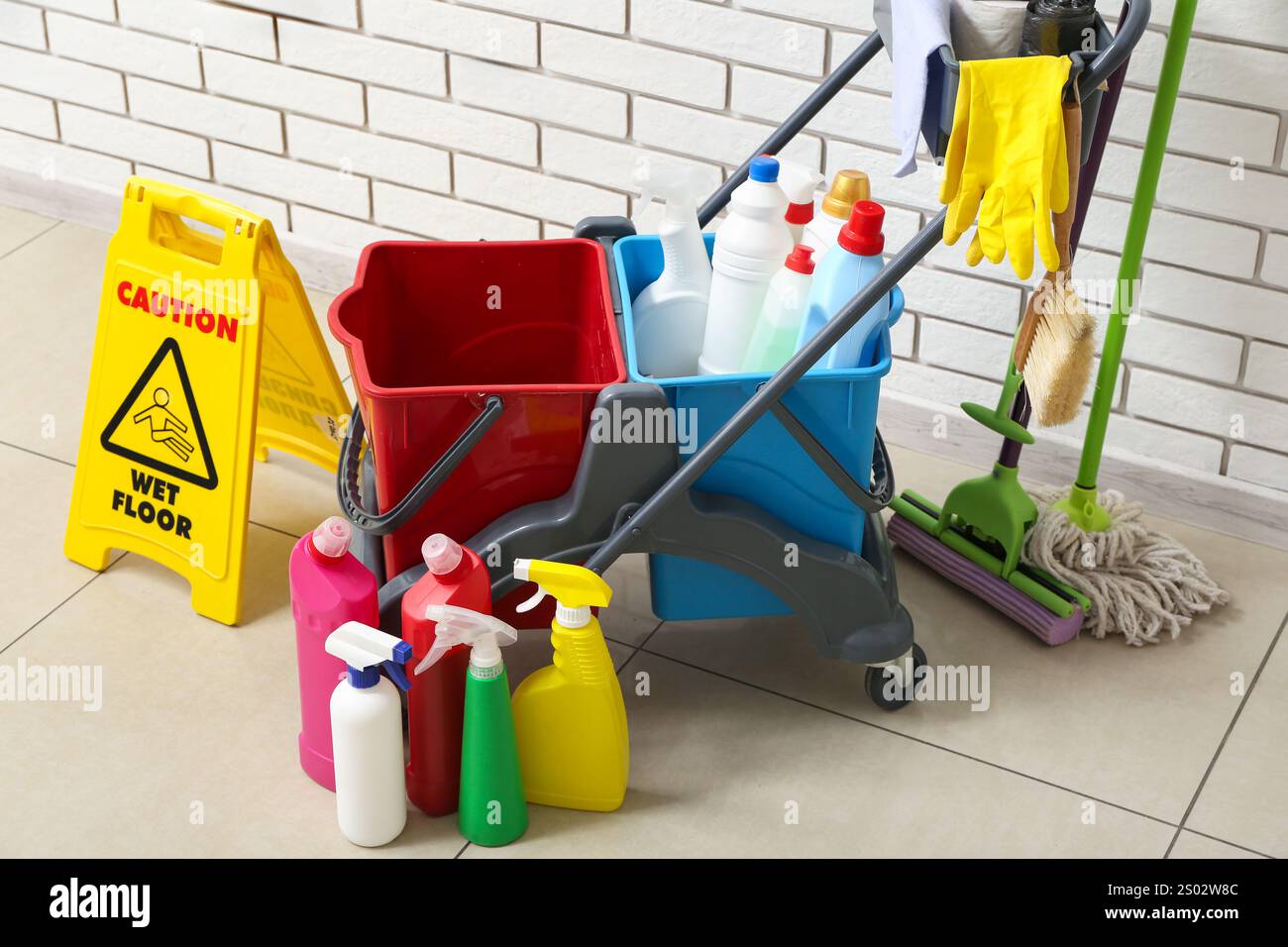 Caution sign with janitor's trolley near white brick wall Stock Photo ...