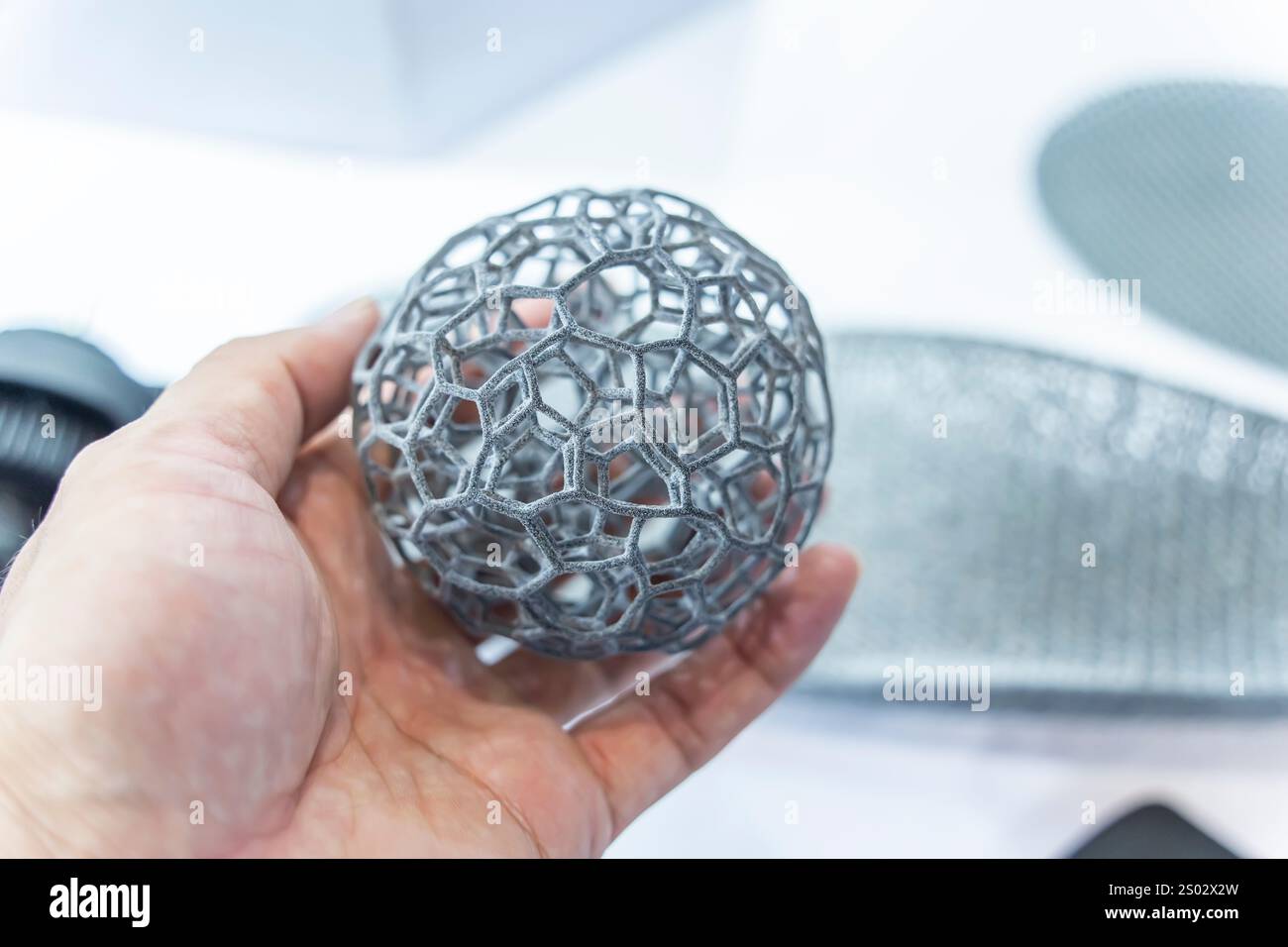 hand with hollow sphere object printed on 3d printer close-up Stock Photo