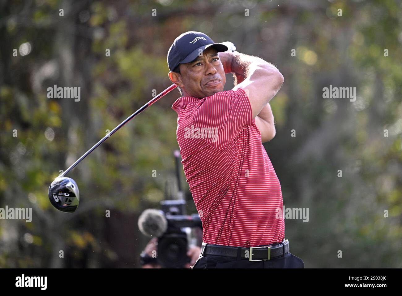 Tiger Woods tees off on the 14th hole during the final round of the PNC