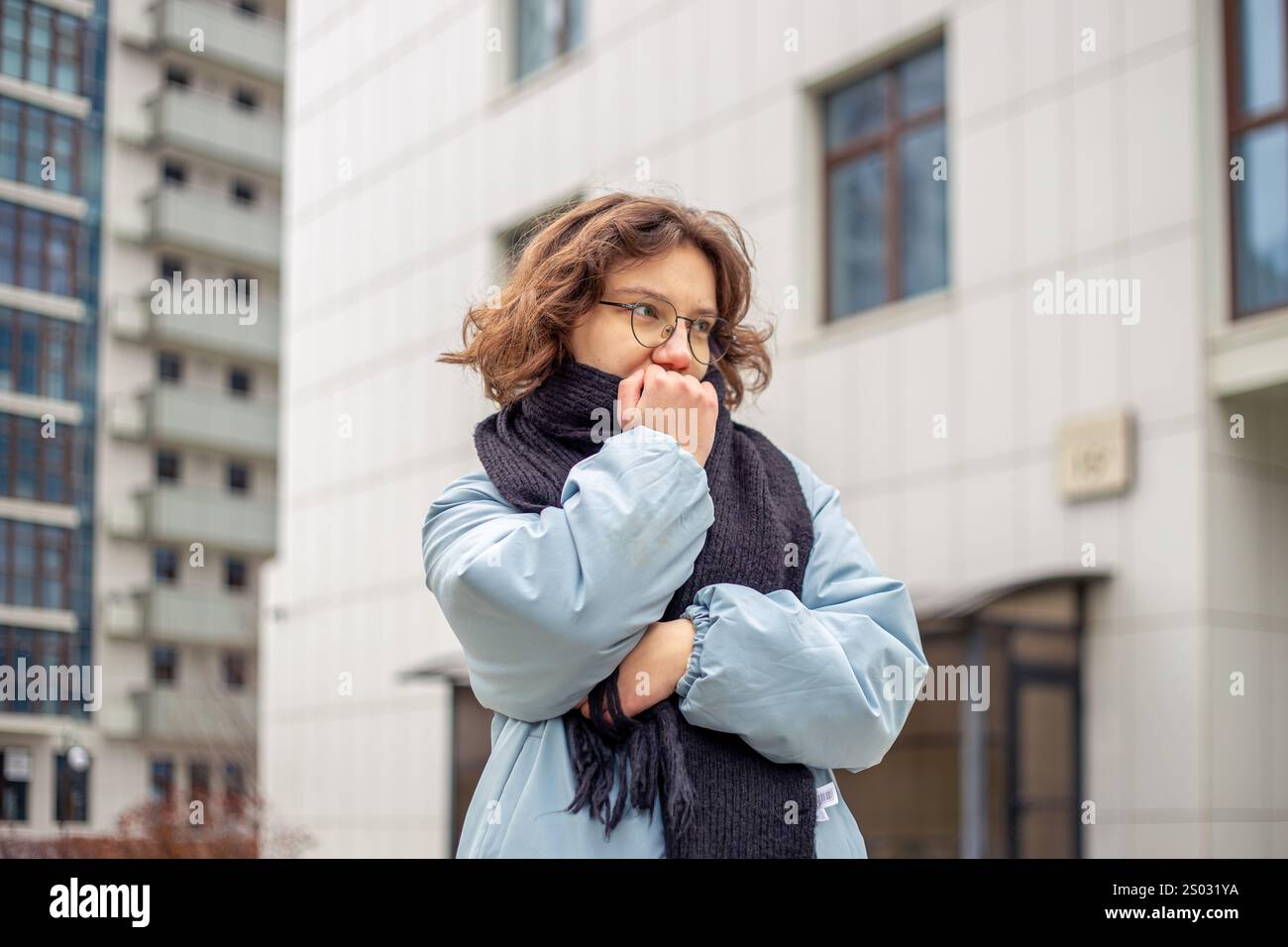 Freezing woman. A young beautiful frozen girl suffers from cold weather ...
