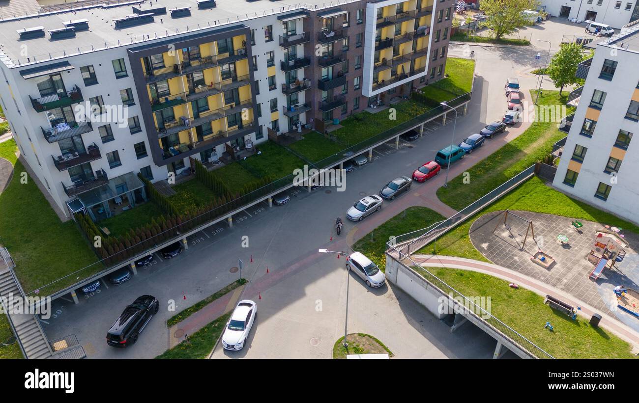 Aerial view of a modern residential apartment complex with parked cars ...