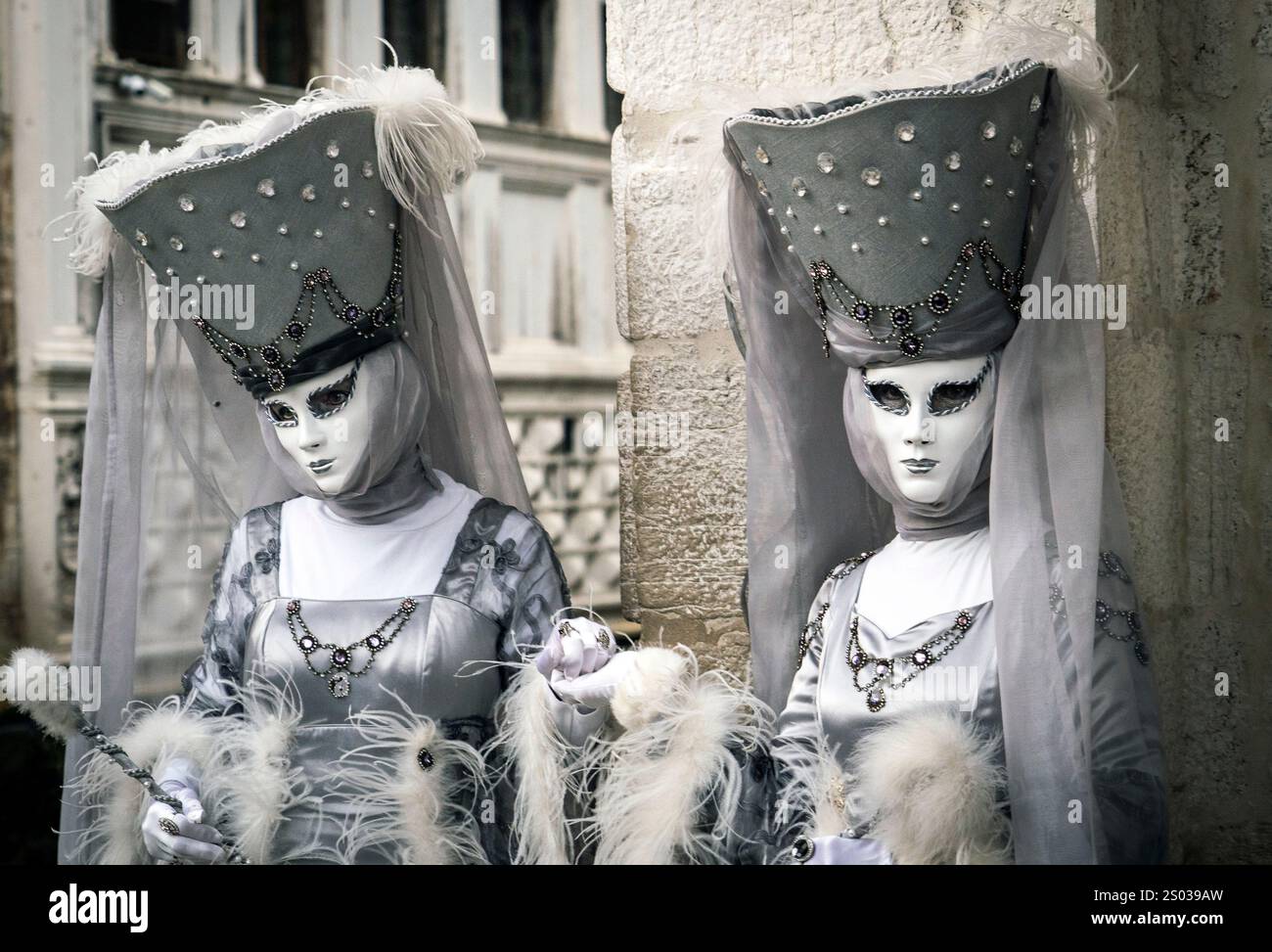 Two elegantly dressed figures in elaborate costumes and masks ...