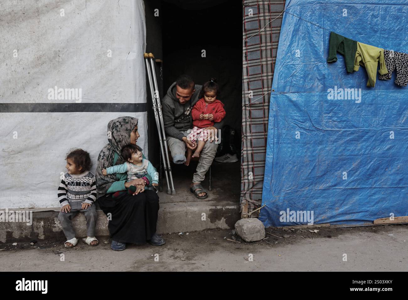 Palestinian displaced person Riyad Abu Sharkh, 26 years old, sits with ...