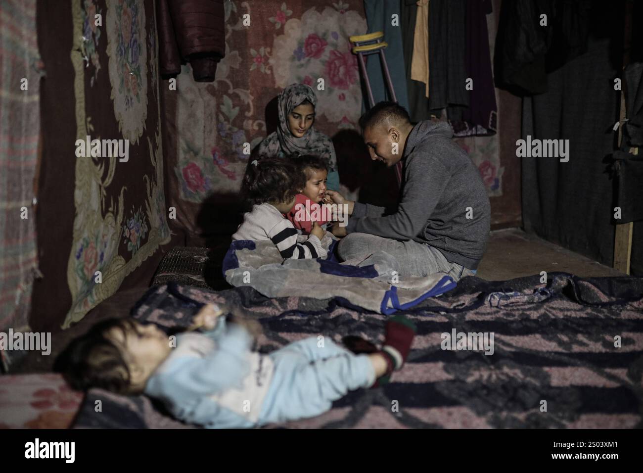 Palestinian displaced person Riyad Abu Sharkh, 26 years old, sits with ...