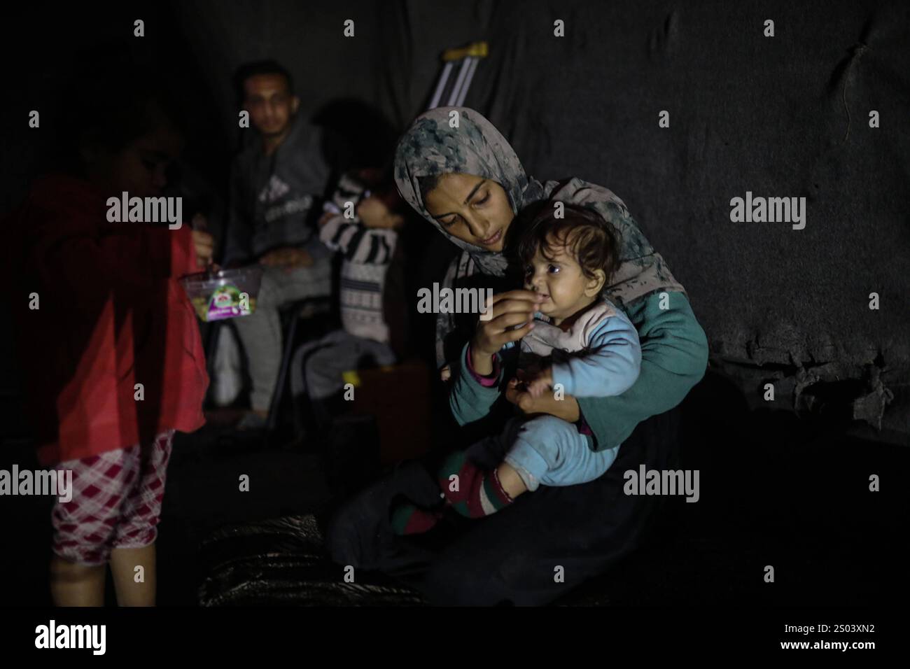 Palestinian displaced person Riyad Abu Sharkh, 26 years old, sits with ...