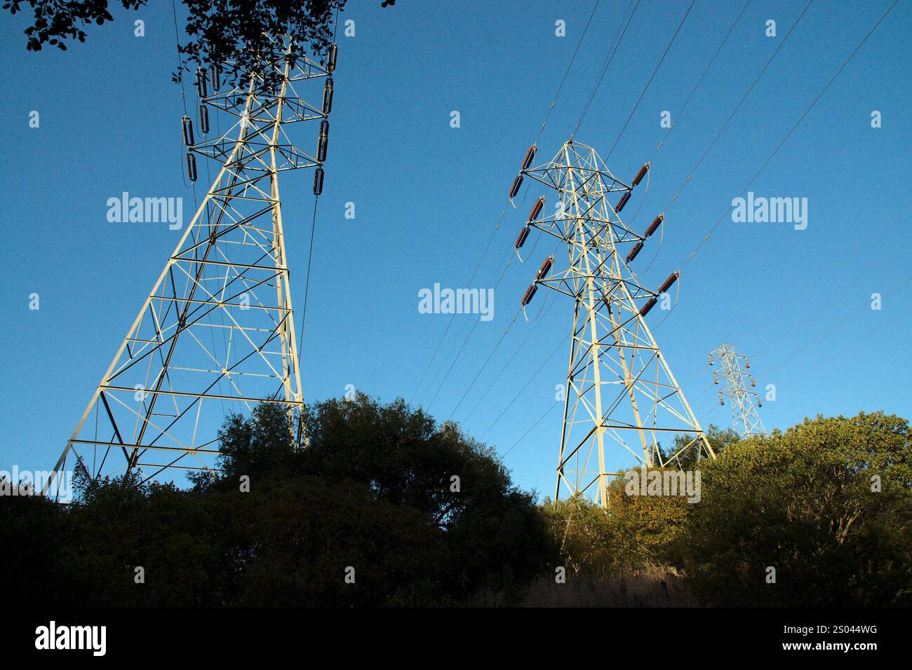 Electrical power transmission lines and towers against a blue sky Stock ...