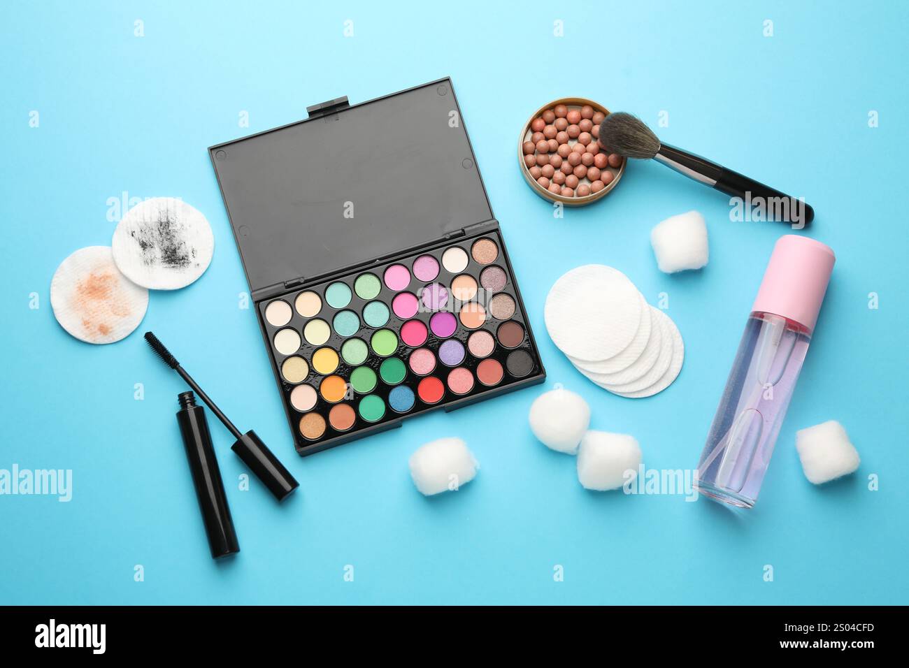 Flat lay composition with cotton pads and makeup products on light blue ...