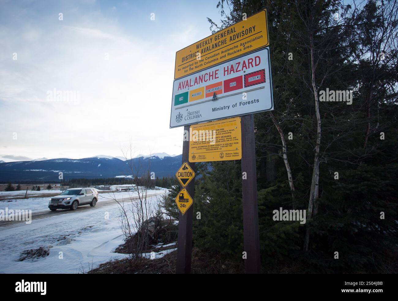 A vehicle passes a sign showing an avalanche hazard warning of ...