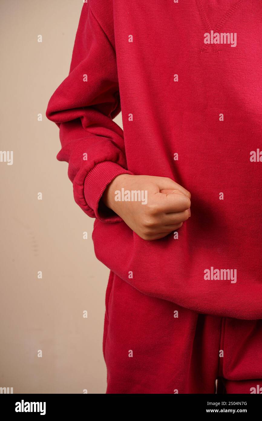 A raised clenched fist stands out against a light wall, symbolizing strength and inner strength. The neutral background draws attention to the decisiv Stock Photo