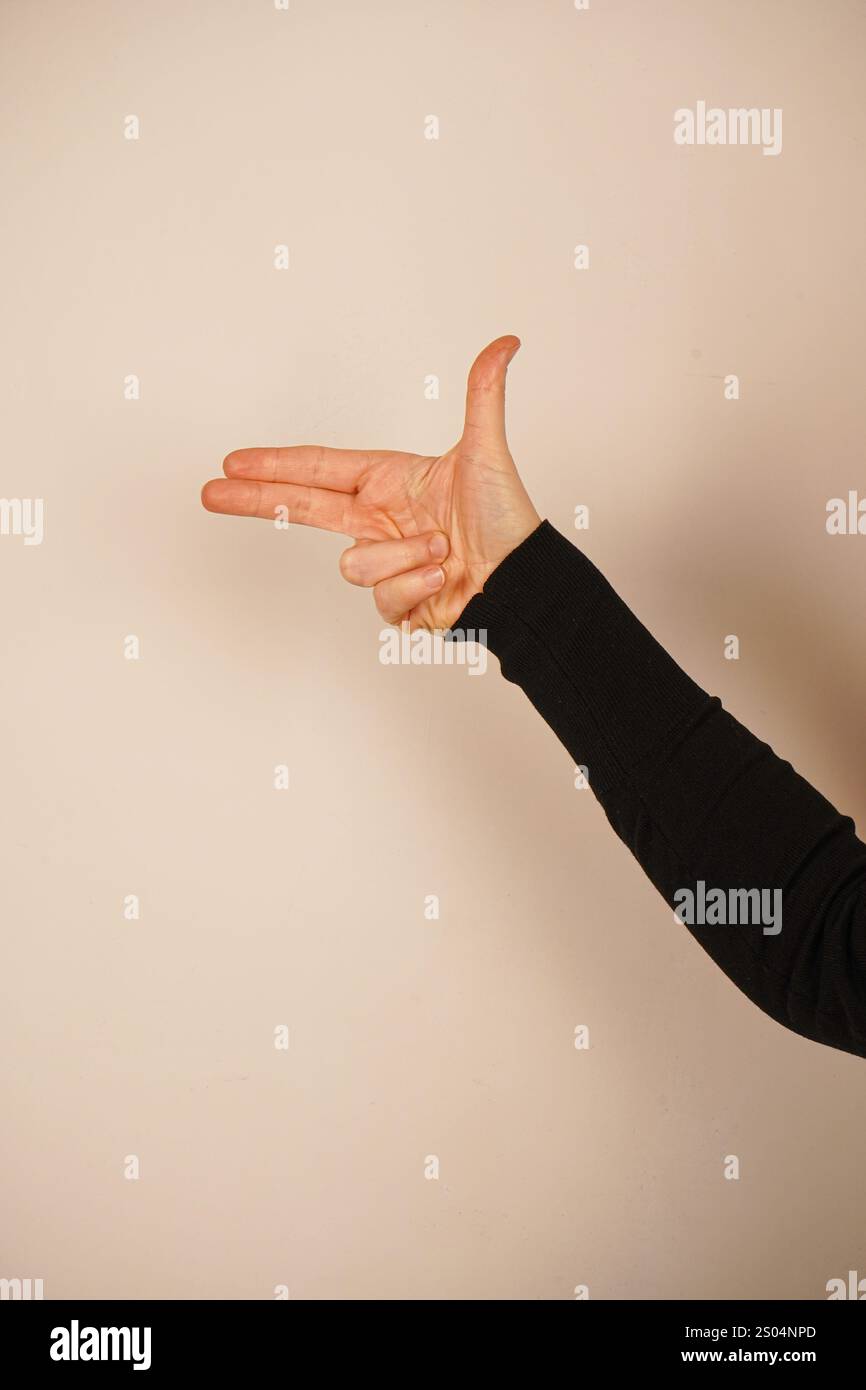 Fingers are arranged to mimic the shape of a gun, creating a playful ...