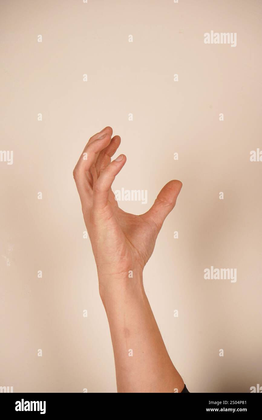 The hand takes on a claw-like shape, resembling a cat s paw. Fingers are bent and spread apart, evoking the agility and sharpness of felines. This ges Stock Photo