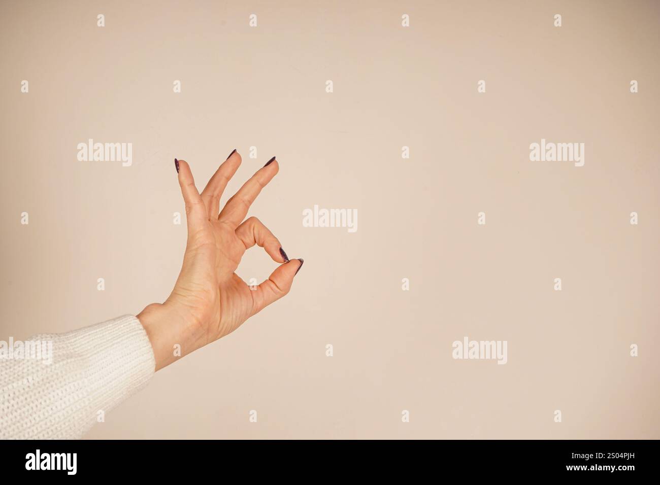 The thumb and index finger form a loop, with the other fingers raised ...