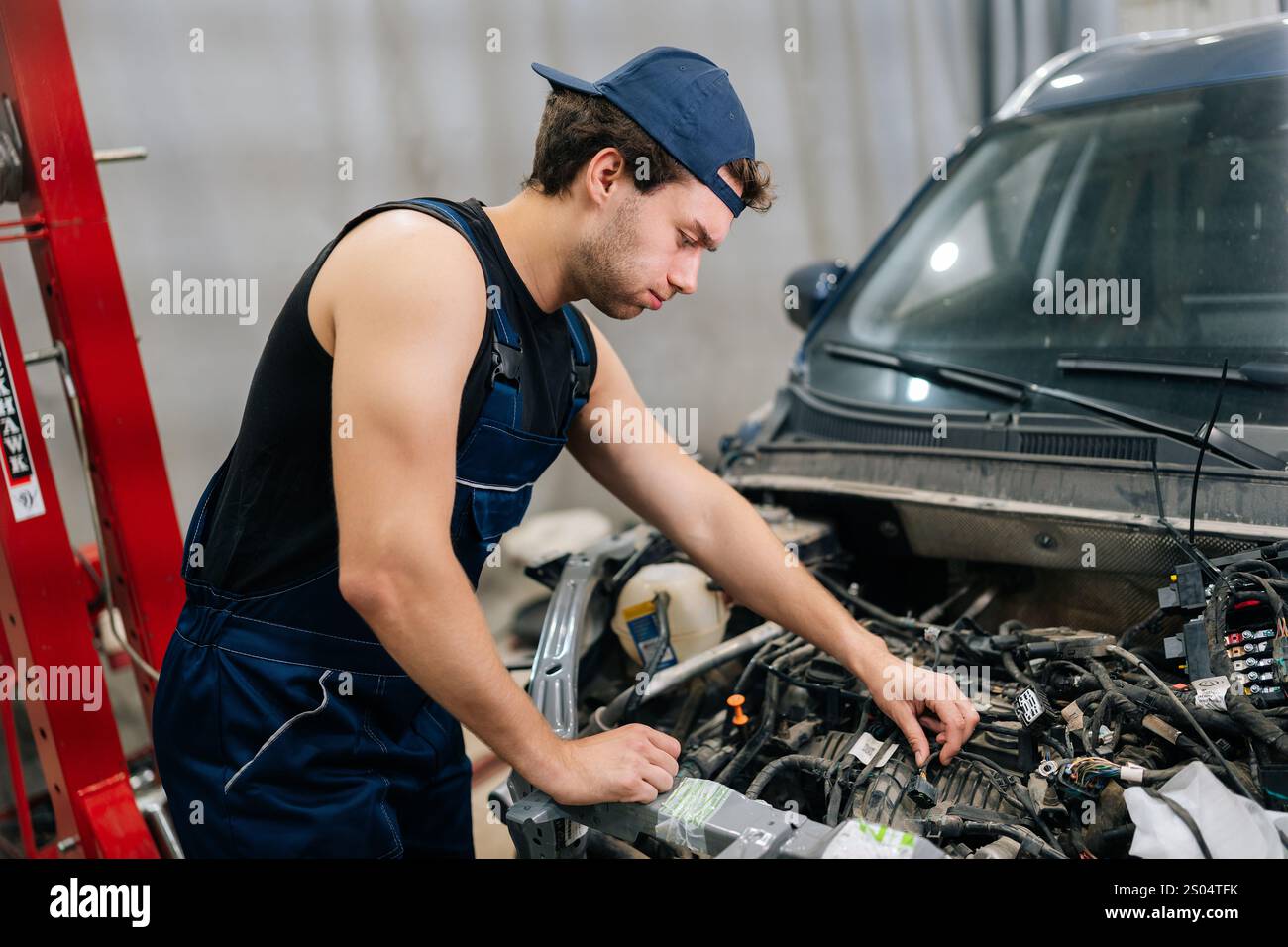 Workcomp Mechanic Muscular automotive mechanic male check up engine of old car. Serious ...