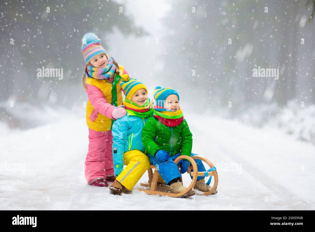 Kids play in snow in winter park. Children playing outdoors on snowy ...