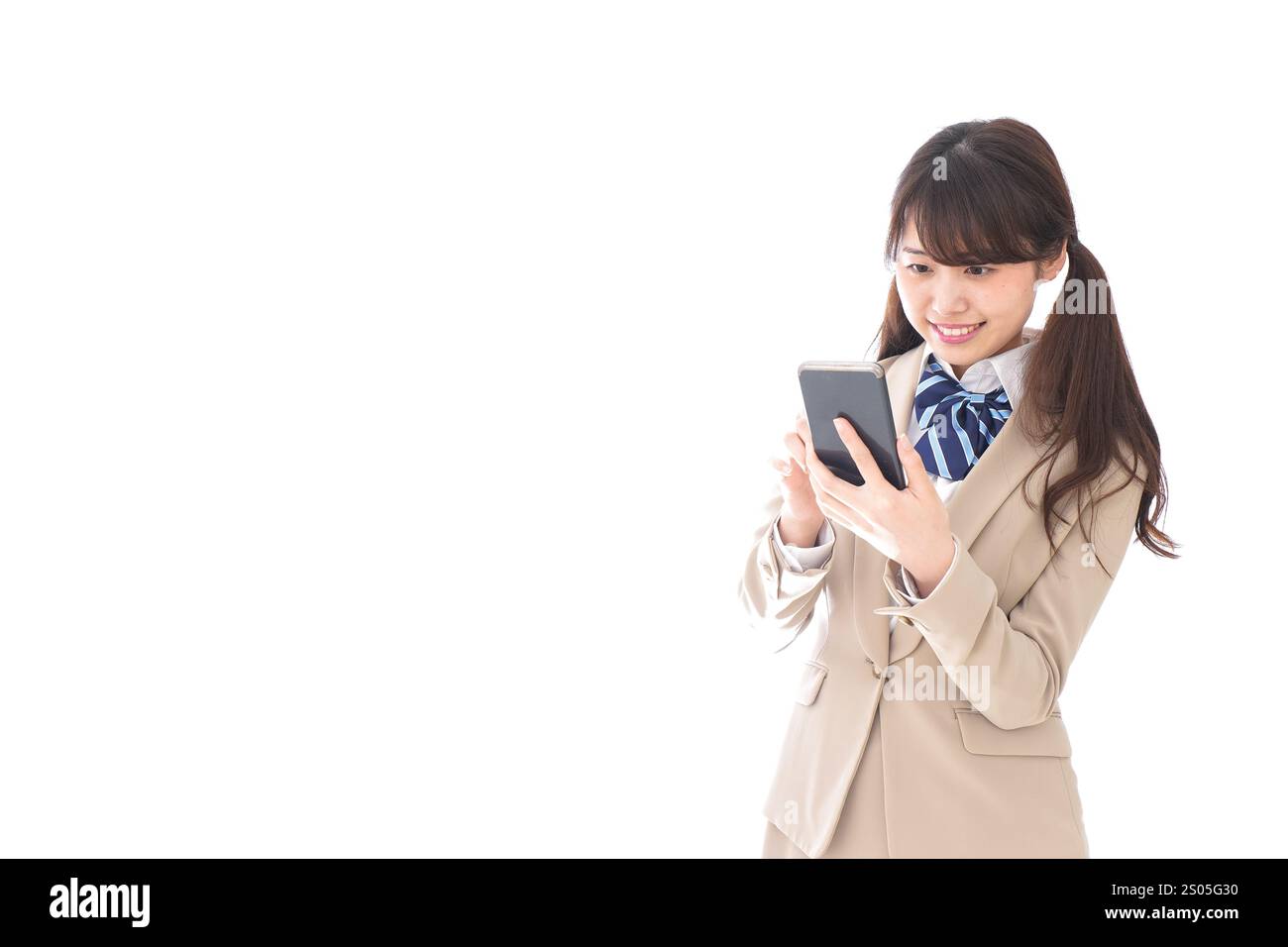 Student in school uniform using a smartphone Stock Photo