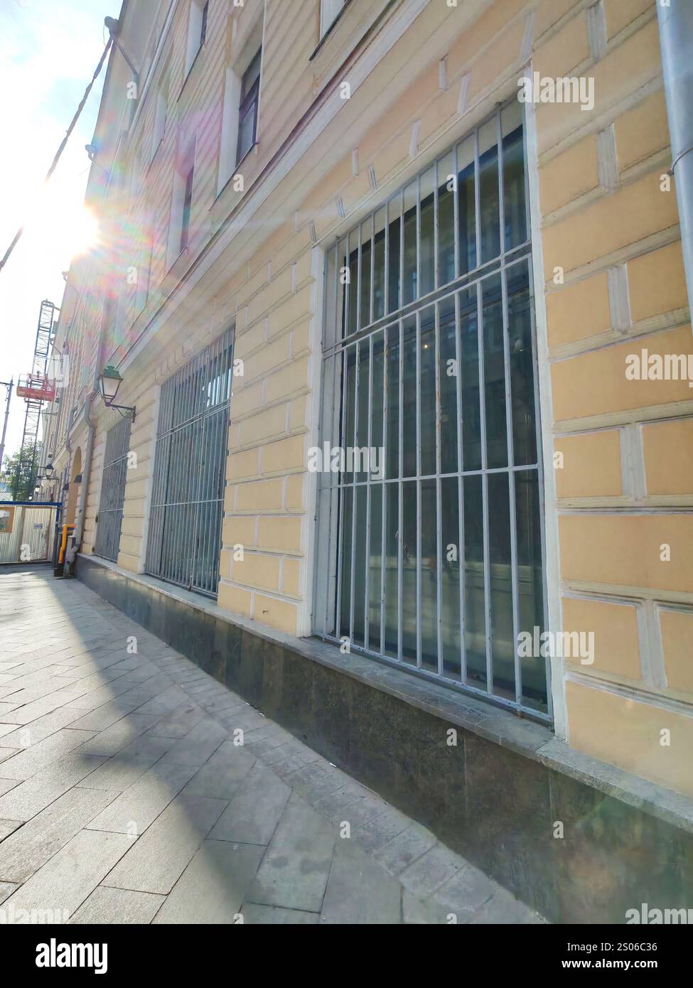 A close-up view of a beige building with wooden-framed windows and ...