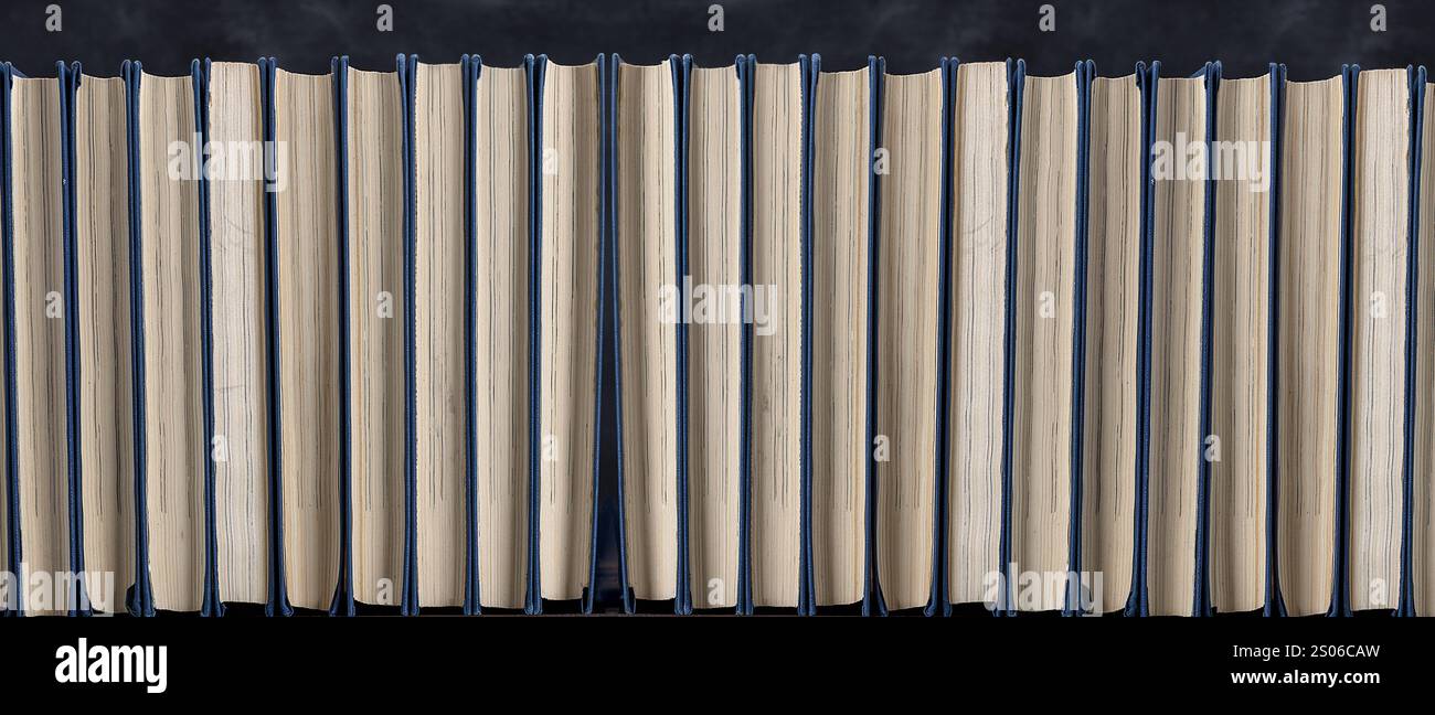 Shelf with books in a row on a black background Stock Photo - Alamy