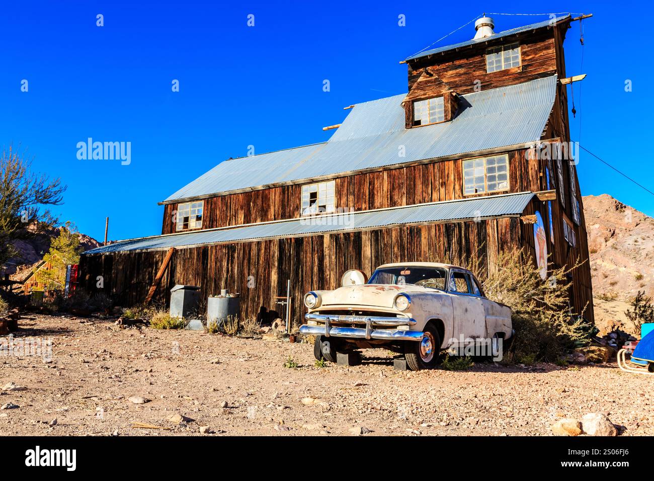 A car is parked in front of a large, old building. The car is a vintage ...