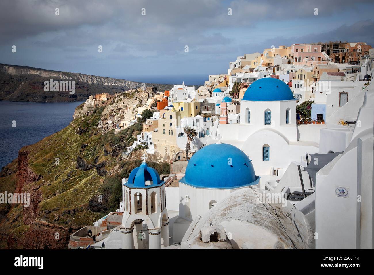 The Perched dramatically on the rugged cliffs of Santorini's caldera, the village of Oia is a breathtaking mosaic of whitewashed buildings. Stock Photo