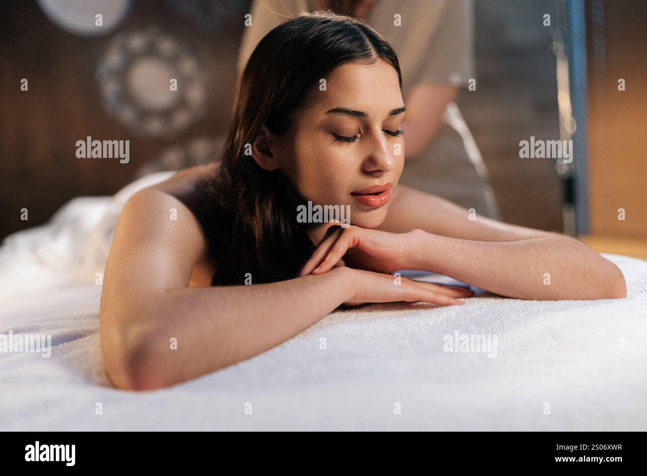 Closeup face of calm woman client relaxing during back massage in spa ...
