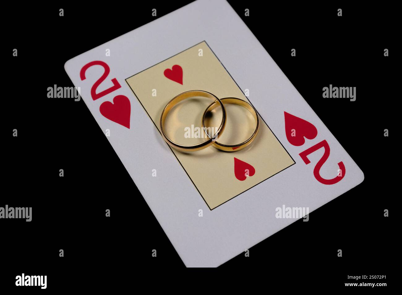 Gold wedding rings on a two of hearts playing card, symbolizing love ...