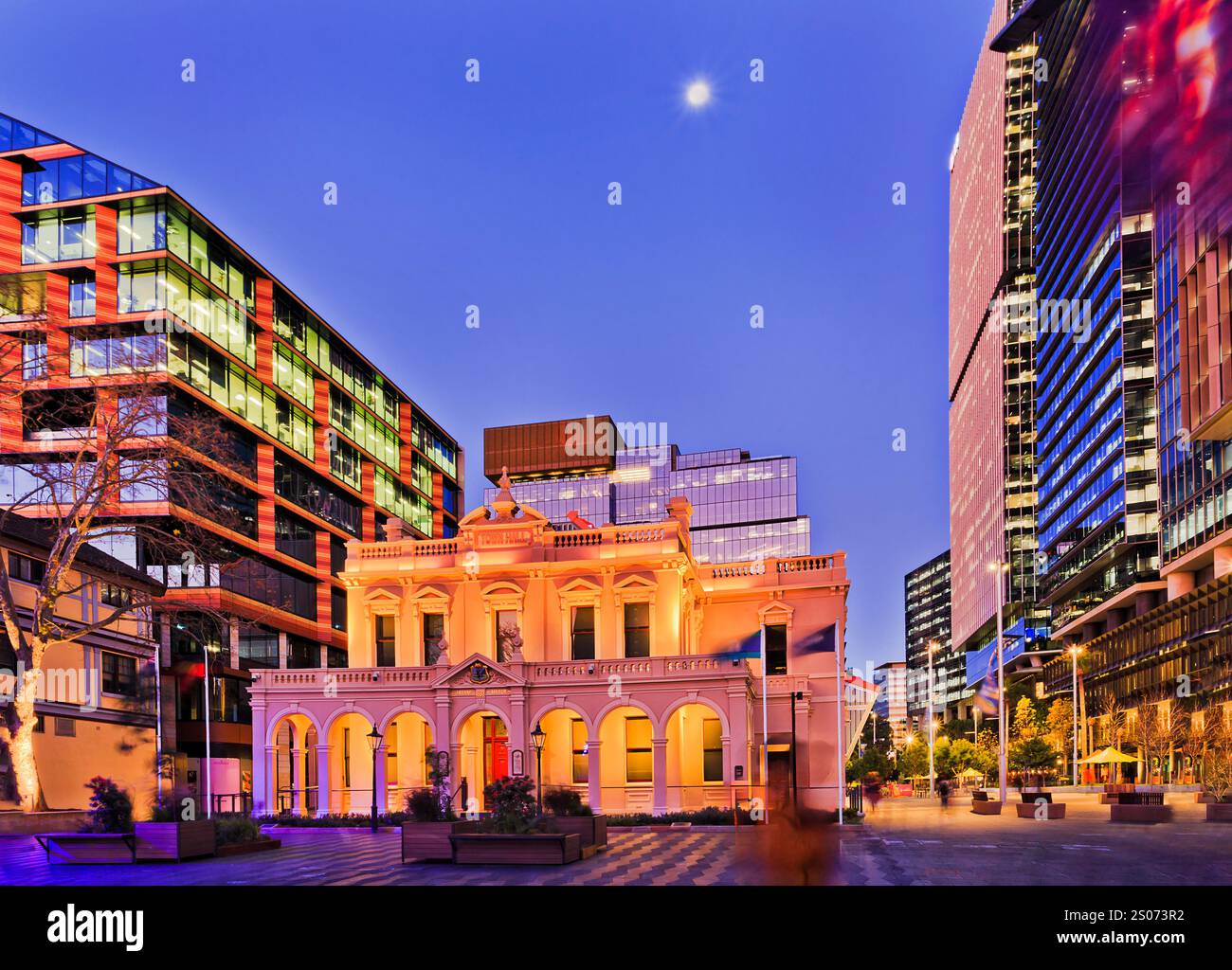 Parramatta city TOwn Hall surrounded by modern tall high-rise office buildings at sunset full moon. Stock Photo