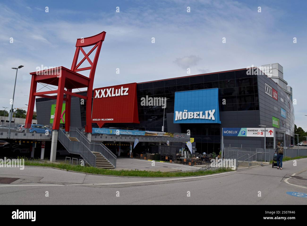 Giant red chair outside the XXXLutz GMBH furniture store in Vienna Austria, June 2024 Stock Photo