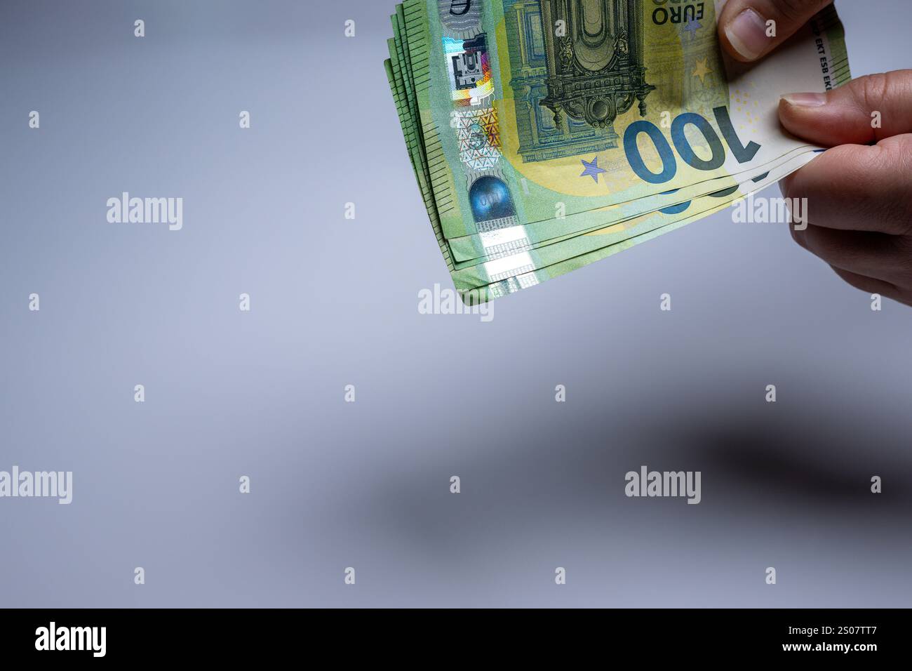 , Deutschland, 26.12.2024,  Hand hält mehrere 100-Euro-Scheine auf einem schlichten Hintergrund. Symbol für Finanzen, Reichtum und Geldgeschäfte. Stock Photo