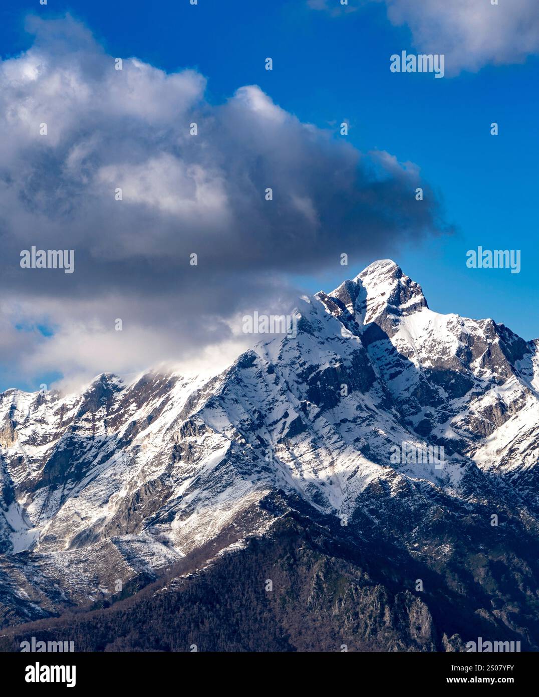 A breathtaking view of snow-capped mountains under a blue sky with ...