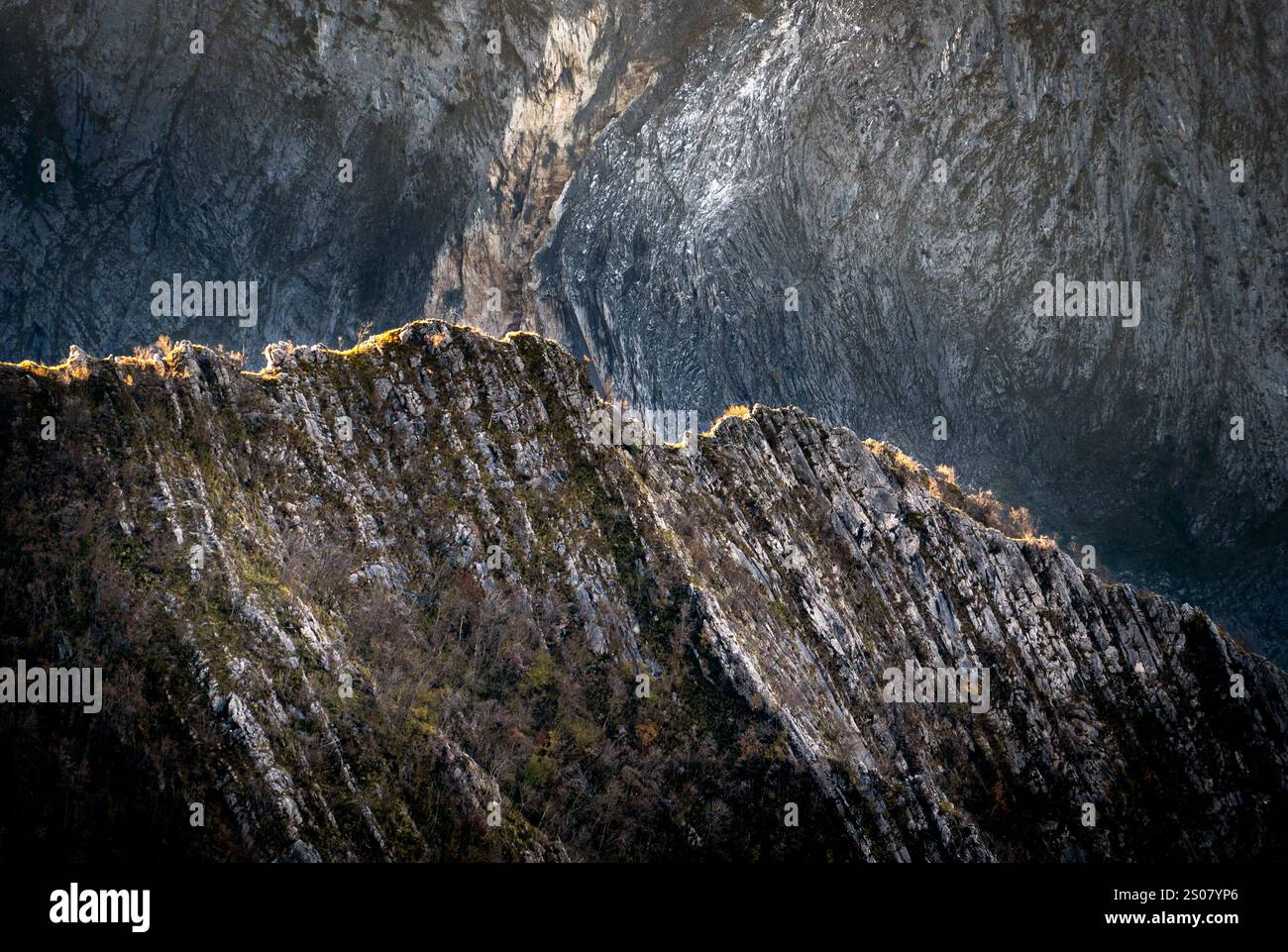 A dramatic mountain landscape showcasing rugged peaks and textured rock ...