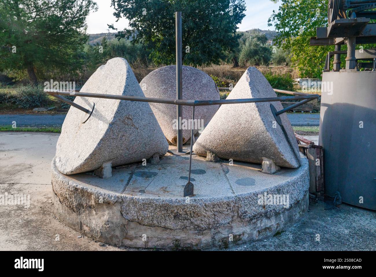 Stone grinding machines used in the production of old-style olive oil, consisting of three cone-shaped stones, Spain Stock Photo