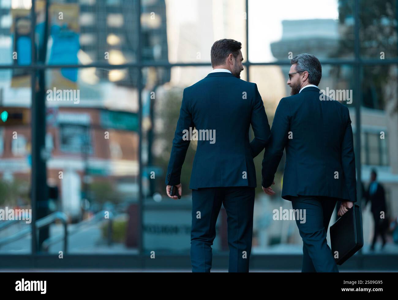 Two businessmen in elegant business suit. Business center. Walking