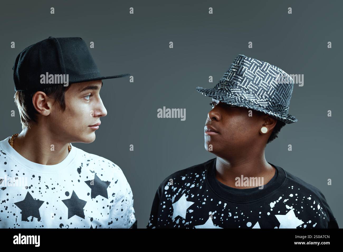 Two young male rappers wearing trendy clothes and hats are looking at ...