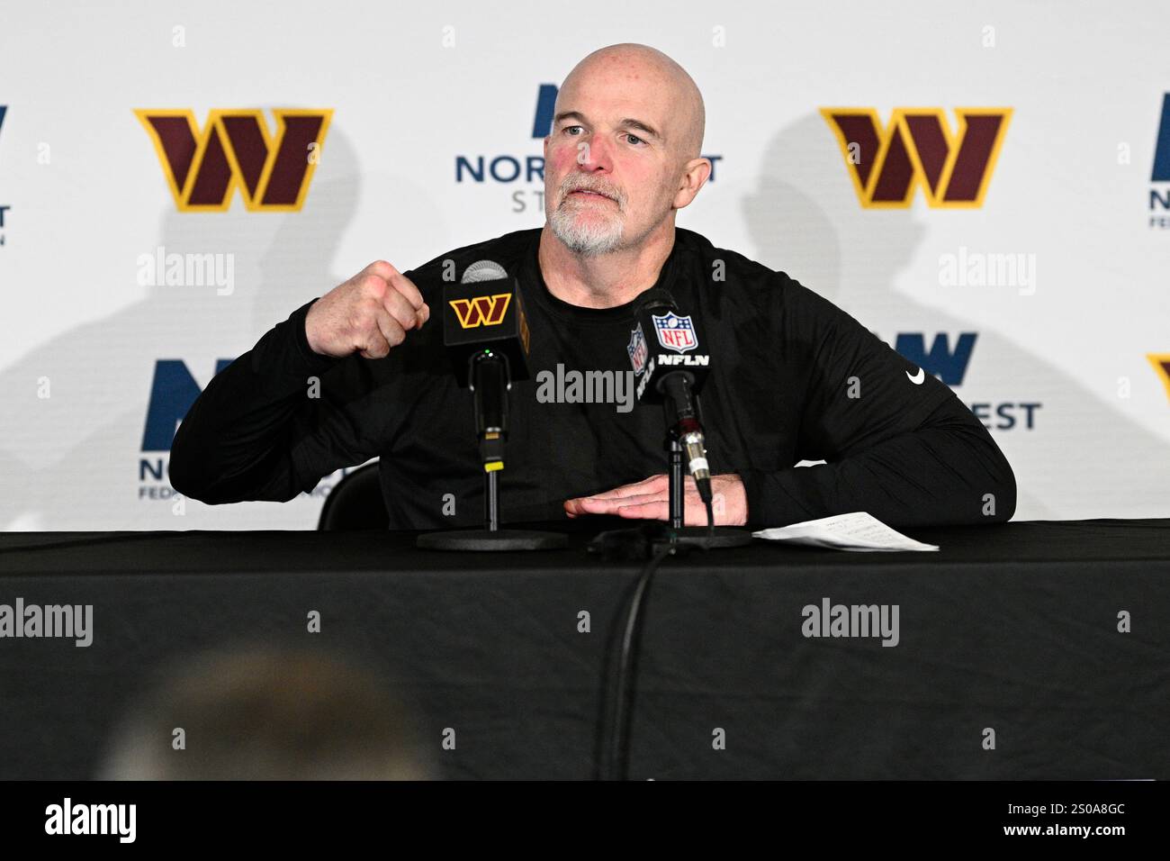 Washington Commanders head coach Dan Quinn talks to the media after an