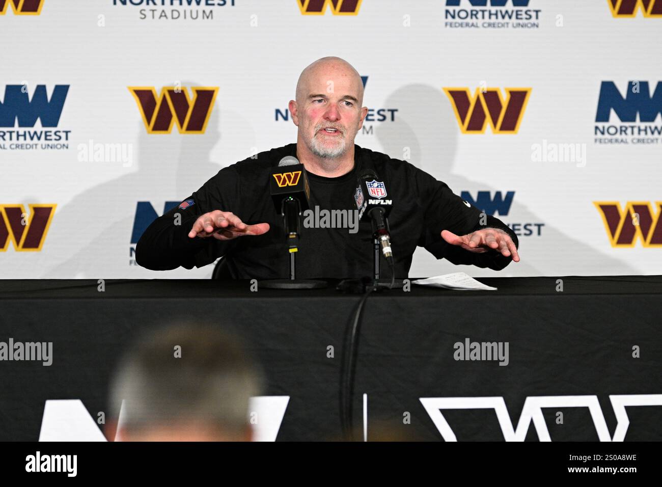 Washington Commanders head coach Dan Quinn talks to the media after an