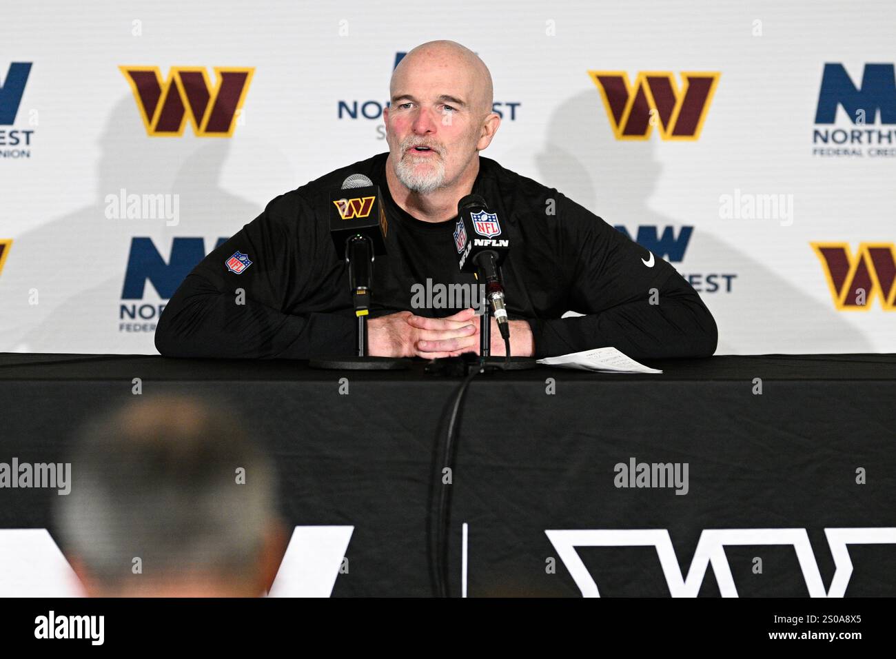 Washington Commanders head coach Dan Quinn talks to the media after an