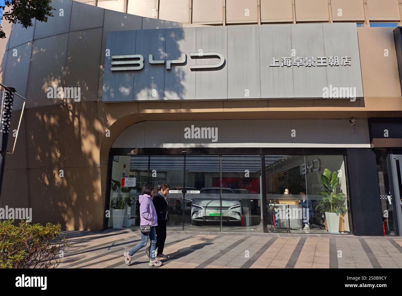 Citizens walk past a BYD auto store in Pudong, Shanghai, China ...