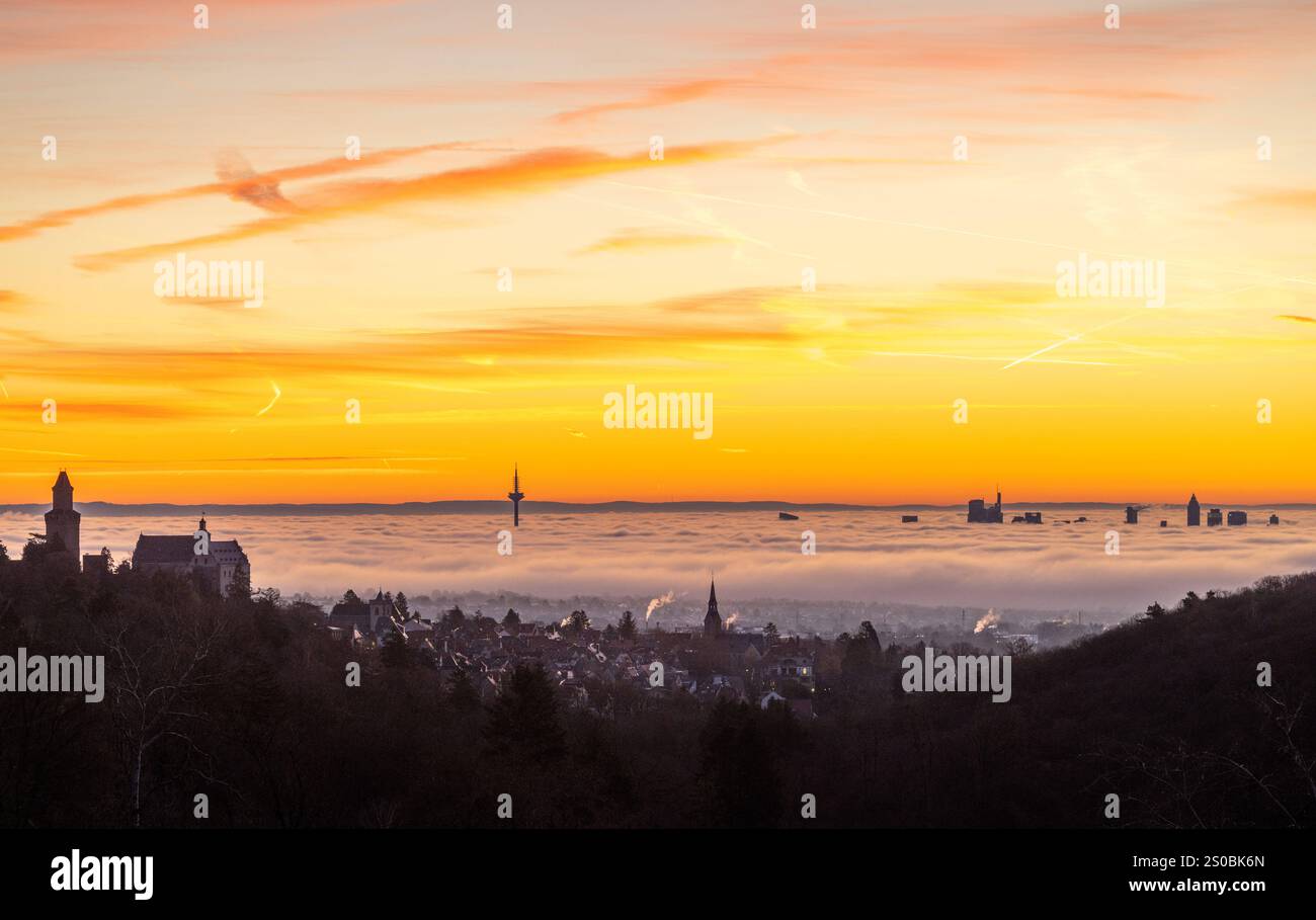 Frankfurt im Nebel Die Hochhäuser der Frankfurter Skyline ragen am Morgen bei Sonnenaufgang aus dem Nebel, links im Bild die Burg Kronberg., Kronberg Hessen Deutschland Stock Photo