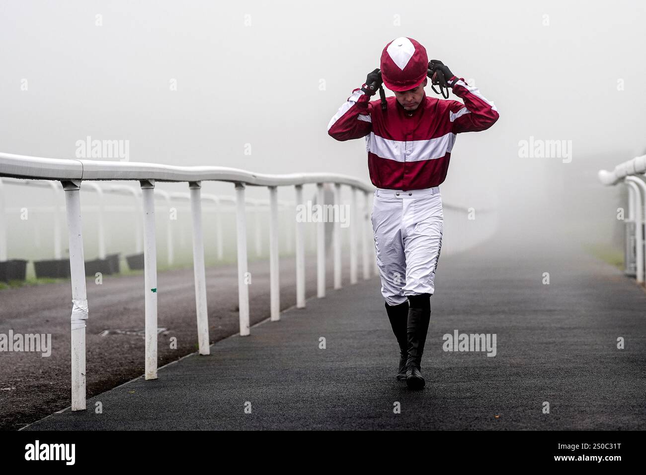 Jockey Liam Harrison heads out for the first race in heavy fog during