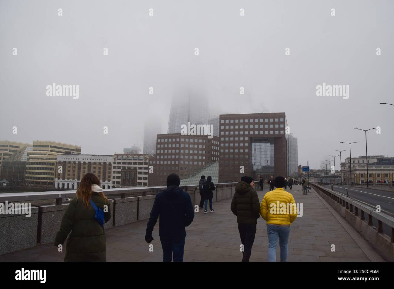 London, UK. 27th December 2024. People walk along London Bridge past an obscured Shard building as fog descends on the capital. Credit: Vuk Valcic/Alamy Live News Stock Photo