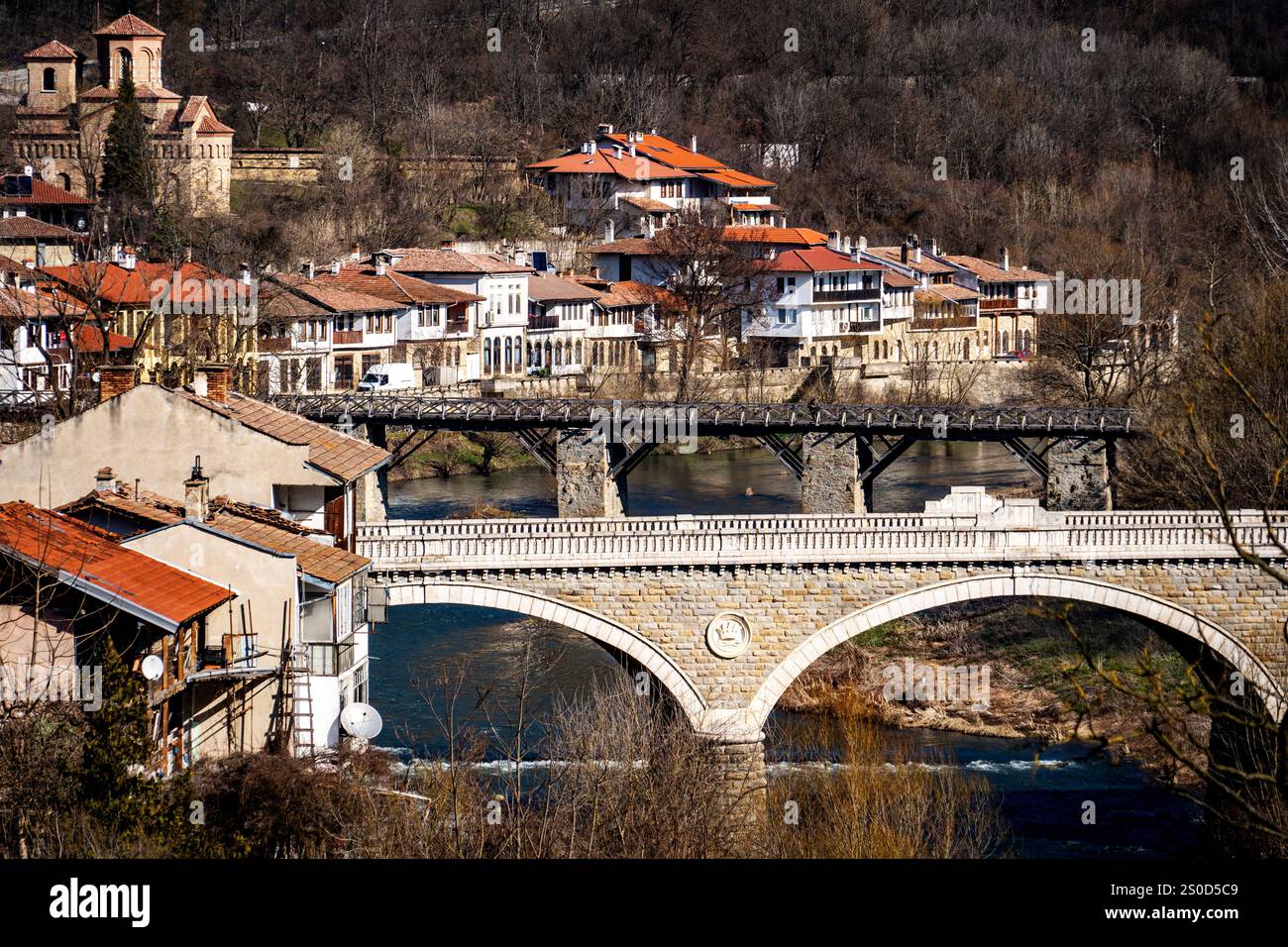 A scenic view of a historic European town with a stone bridge crossing ...