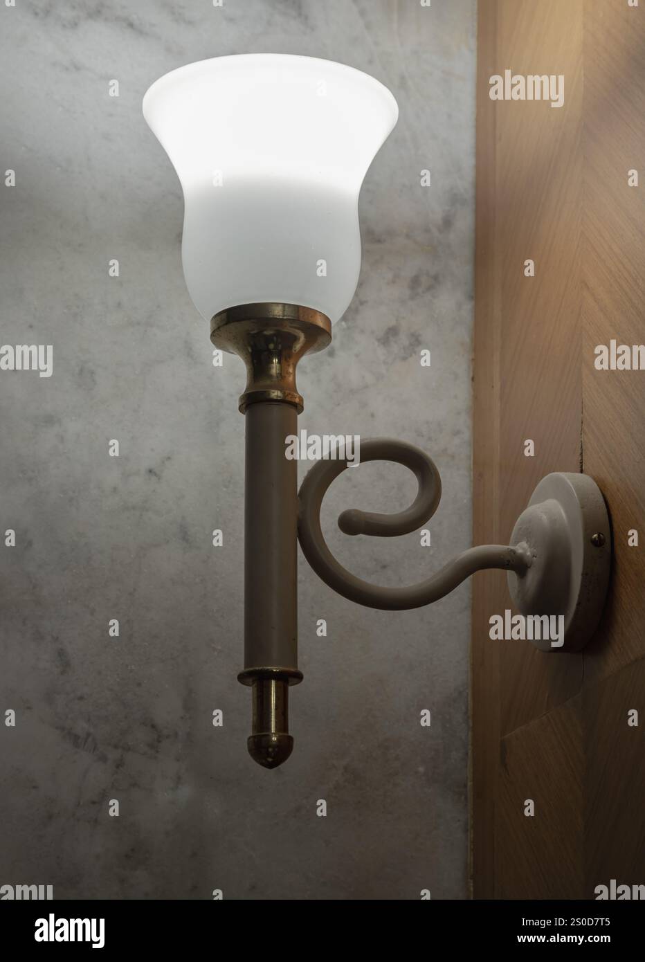 Old vintage lamp illuminated on the wooden wall (uplighter). Classic metal wall lamp, Lamp create a warm and elegant ambiance, perfect for vintage-the Stock Photo