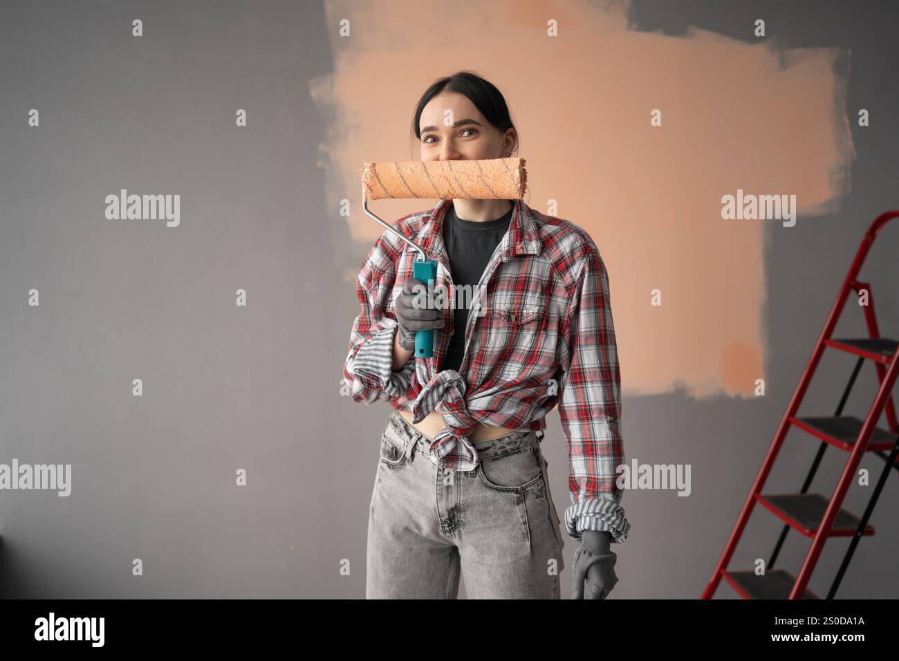 Happy beautiful young woman painting walls. Copy space Stock Photo - Alamy