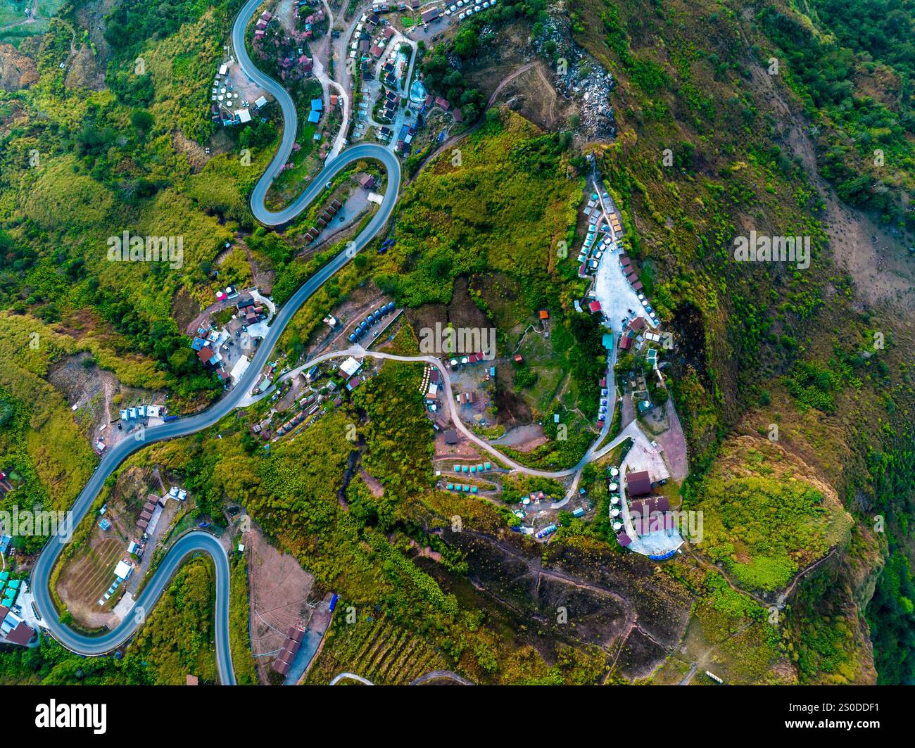 aerial view of a winding mountain road surrounded by lush greenery ...