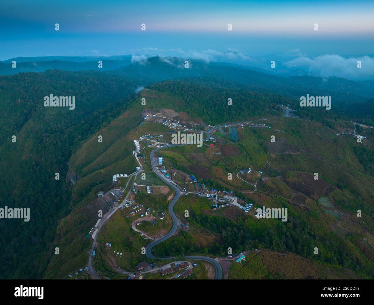 aerial view of a winding mountain road surrounded by lush greenery ...