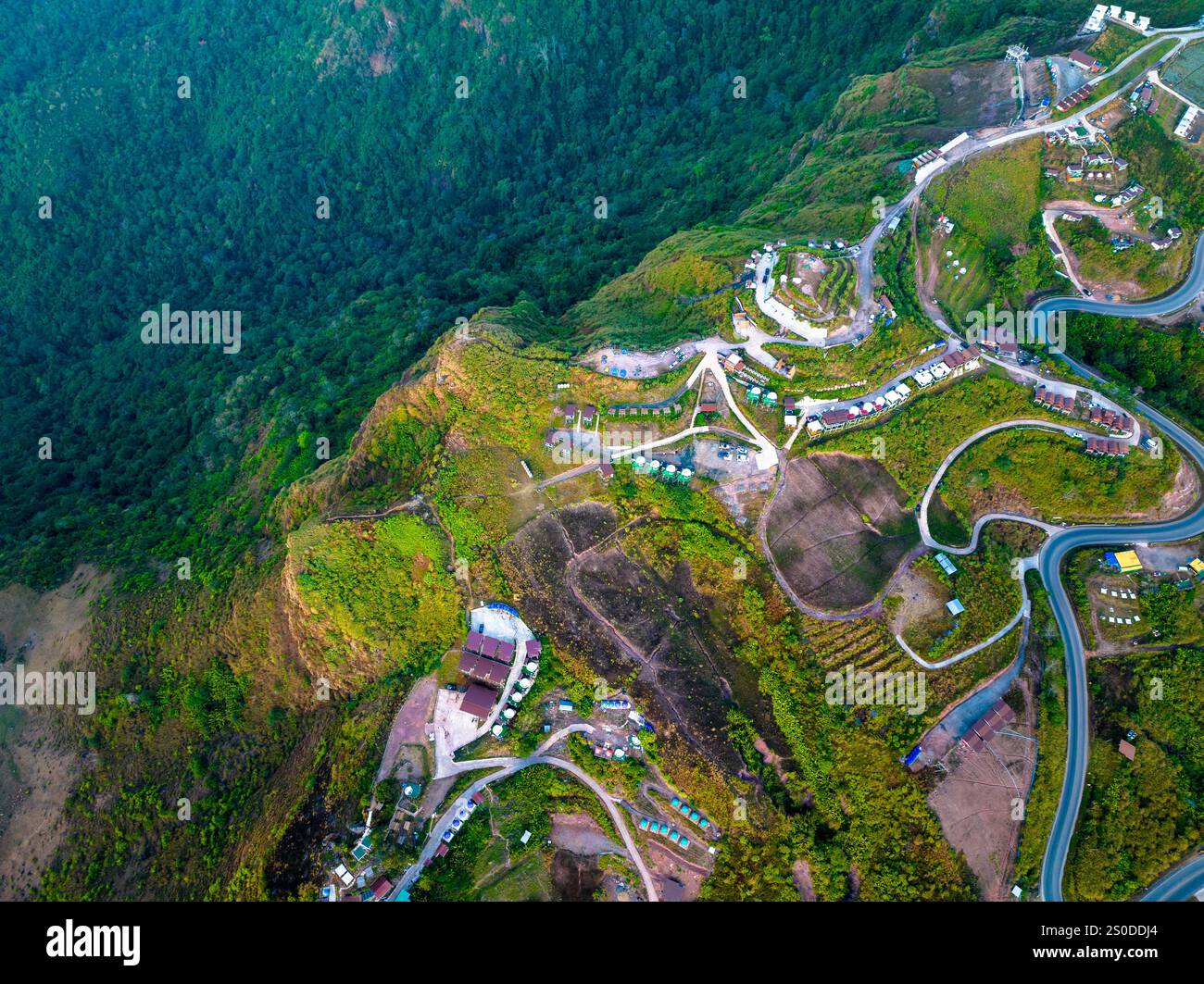 aerial view of a winding mountain road surrounded by lush greenery ...