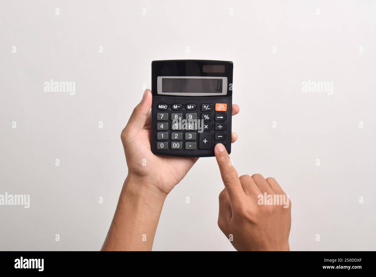 Hands holding and using a calculator isolated on a white background Stock Photo