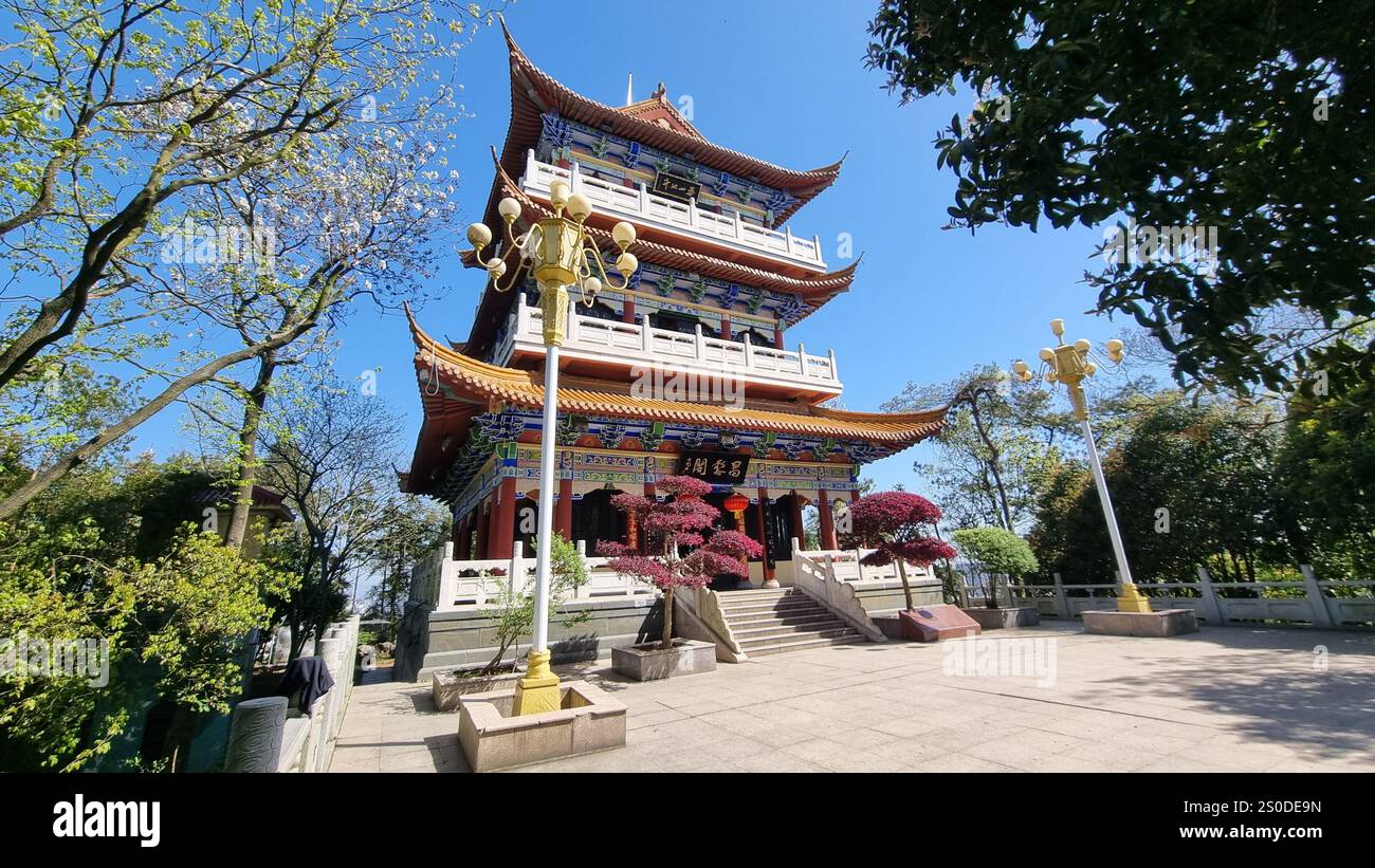 A traditional Chinese-style pavilion or pagoda with vibrant red, blue, and yellow accents. Stock Photo