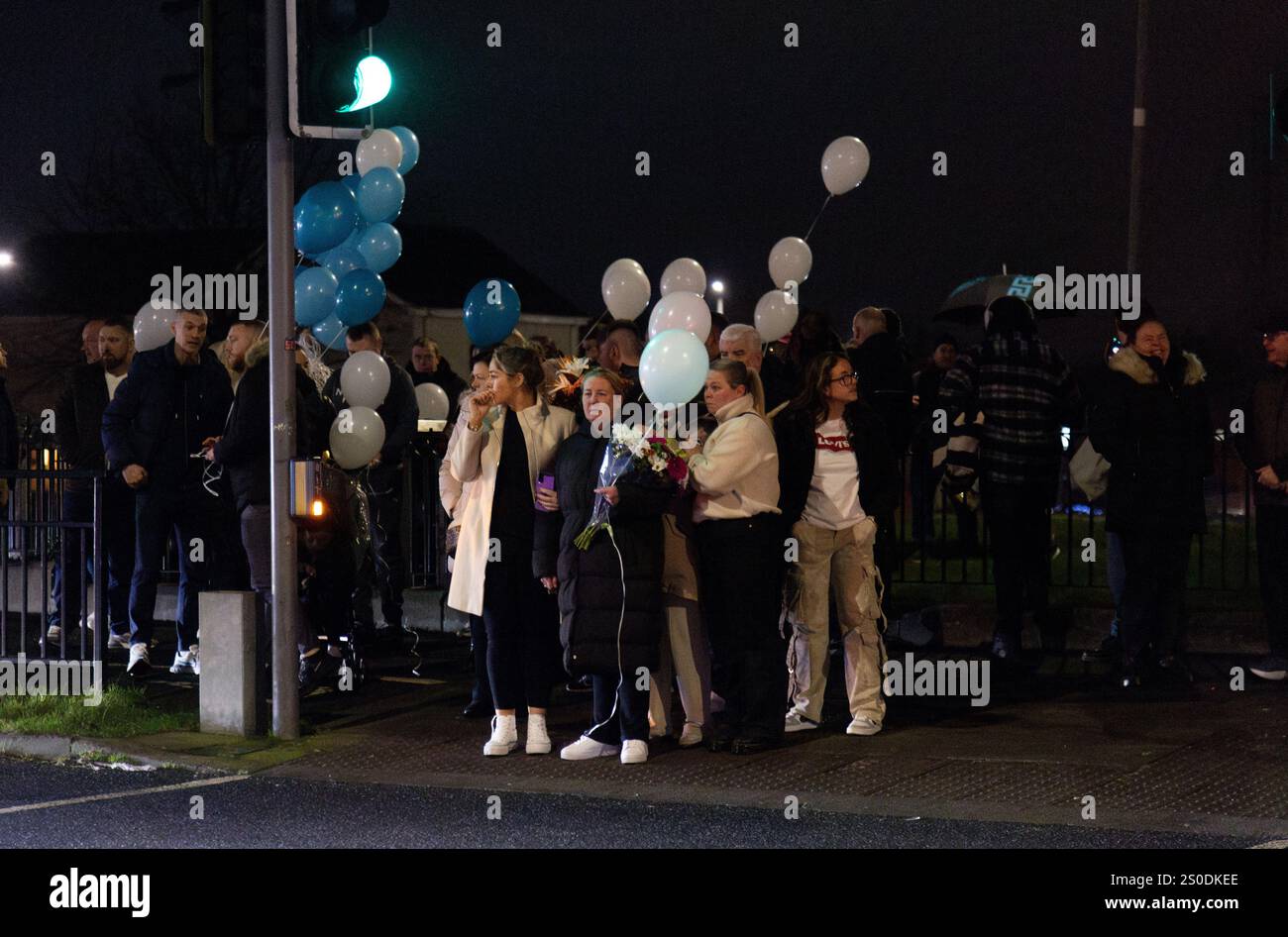 People attend a vigil at the scene on Blanchardstown Road North, west Dublin, where two pedestrians were killed in a hit-and-run incident on Boxing Day. The couple have been named locally as Anthony Hogg and his wife Georgina Hogg Moore. A man in his 40s has been arrested after the incident at about 5.45pm on Thursday. Picture date: Friday December 27, 2024. Stock Photo